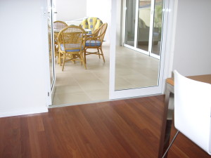 Level entry to the alfresco area of a home showing tables and chairs on the tiled alfresco floor.
