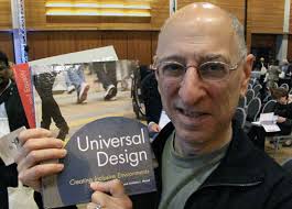 Ed Steinfeld holding his book next to his face. Building accessibility.