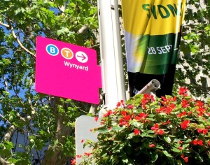 A bright pink sign saying Wynyard and directions to the station.