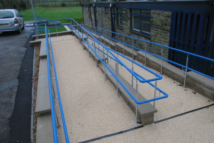 picture showing a zig zag concrete ramp with blue railings