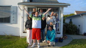 Picture of a large family looking jubilant outside their house