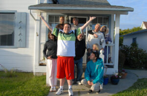 Picture of a large family looking jubilant outside their house