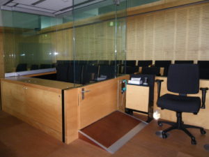 Brisbane court room showing the glass surround for the defendant dock and a short steep ramp to the doorway.