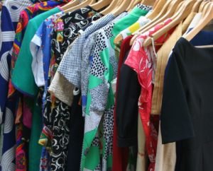 Picture of a rack of dresses in all kinds of fabric designs. Universal design for apparel products.