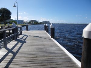 Timber planked pier leading to the ocean. Access to natural waterfront landscapes.