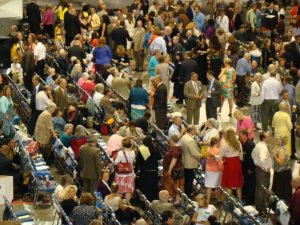 Aerial view of a crowded conference scene where the session has finished and people are standing, sitting and walking about.