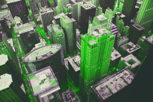 Aerial view of a city with tall buildings. It is a black and white photo with bright green overlay on some of the buildings