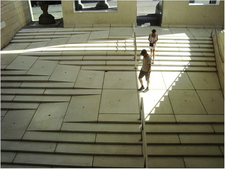 Museum entrance with steps and ramp integrated. The tiles are a light colour and the way the light falls the whole thing looks very confusing.