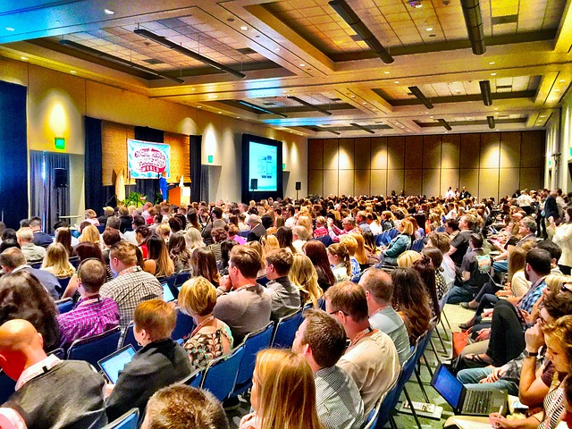 picture of a large audience watching a presentation.