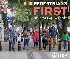 Front cover of the Pedestrians First resource showing a wide footpath with people of all ages walking across the full width of the path.
