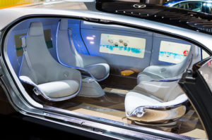 Internal view of a driverless car showing seats facing both back and forward.