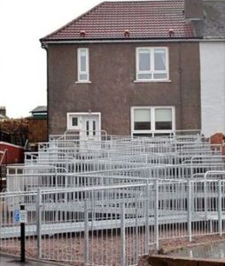 A suburban house in UK. The ramp makes several zig-zags up the front of the house. It looks ugly.