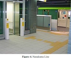 Train platform showing wheelchair crossings across a strip of yellow tactile markers.