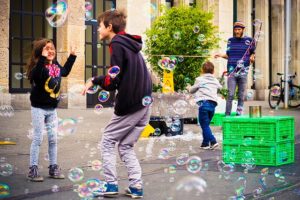 Children play with bubbles in urban area.
