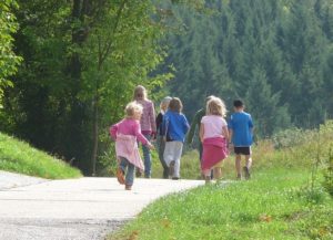 A group of children are walking along a path in a nature park.