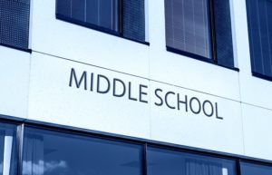 Close up of a school building with the words, middle school. They need the optimum classroom design.