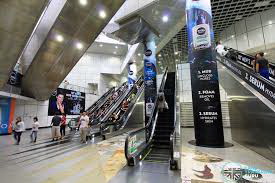 Station in Singapore showing complexity of design with escalators and shiny surfaces.