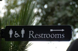 Directional sign to toilets in an outdoor area. Toilets, taboos and design principles.