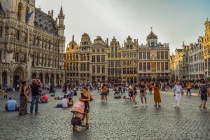 A city square in Belgium showing heritage architecture. People are milling about in the square in Brussels.