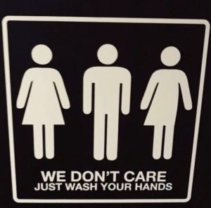 A toilet sign with three icons: one indicating female, one male, and one both. The words are we don't care - just wash your hands.