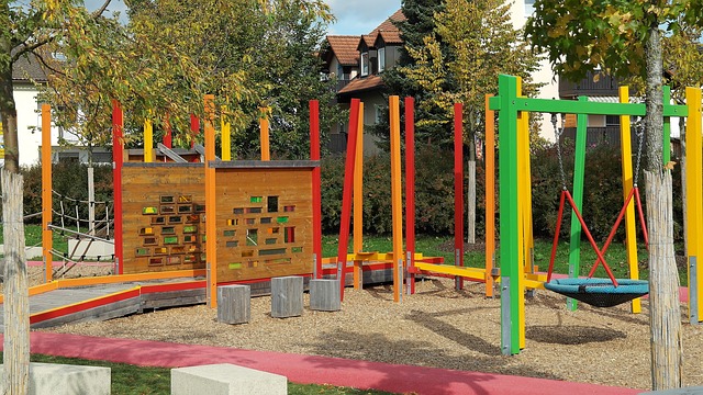 A play area showing brightly coloured poles and a boardwalk leading to equipment.