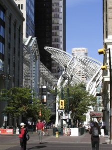 Downtown Calgary showing a pedestrian mall with tall buildings on each side. The sun is shining.