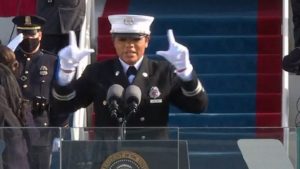 Firefighter Andrea Hall in full dress uniform and white gloves signs during the inauguration of Biden and Harris.