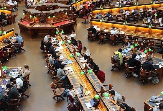 Aerial view of a large public library with long desks around a central console. 