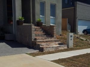 Front of a new house with 12 steps to the front door showing why construction code changes are needed..