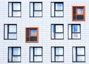 A white brick building with blue framed windows. Social value of good design. 