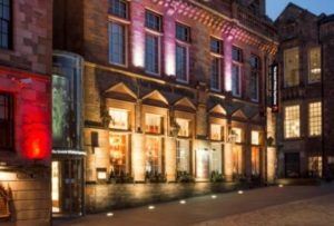A heritage building in Scotland at night with nice lighting from the windows. Accessibility guides like this encourage more visitors.