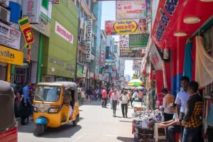 A busy street in Sri Lanka with a tuk tuk and pedestrians. Compliance, heritage and accessibility. 