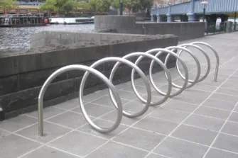 Stainless steel coiled along the footpath to create a place to park bicycles.