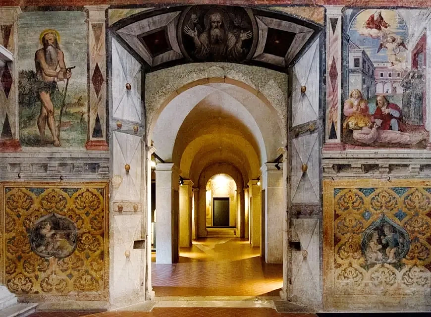 A view of the interior of the museum showing painted walls and a long arched corridor.