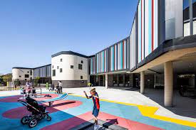 Outside the new school building showing the multicoloured playground of St Lucy's School.