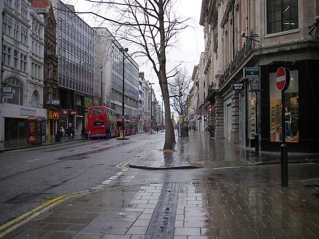 A wet wintery street scene in London showing a line of mid-rise buildings and shops. 