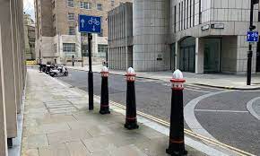 A photo showing a footpath lined with black bollards with white tops from the Street Accessibility Tool.