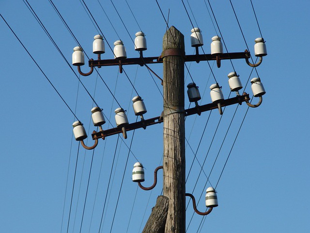 A telegraph pole with rows of wires attached.